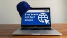 Aufgeklappter Laptop, auf dessen Hülle seitlich eine blaue Mütze sitzt